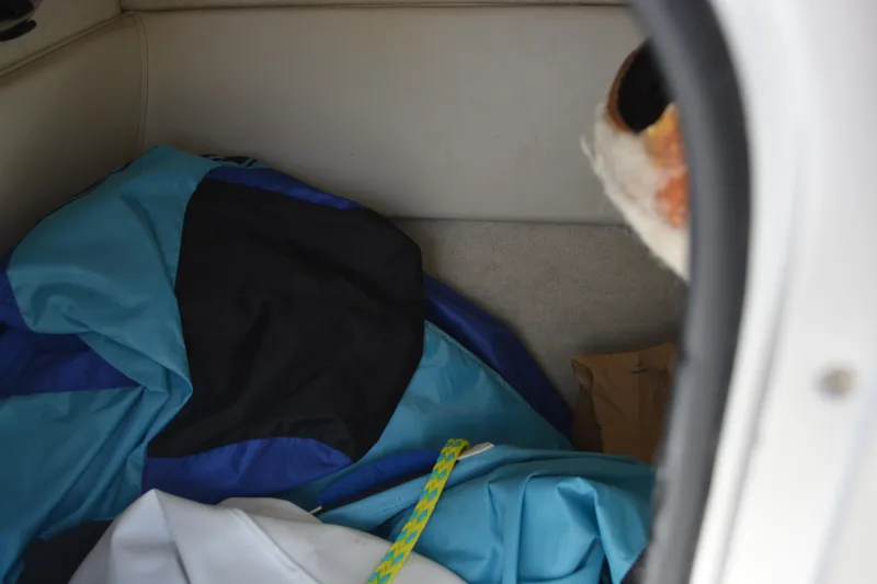 Slide: The Image of Storage compartment of a 1997 Maxum 2300 SR boat with blue and black fabric. - 16