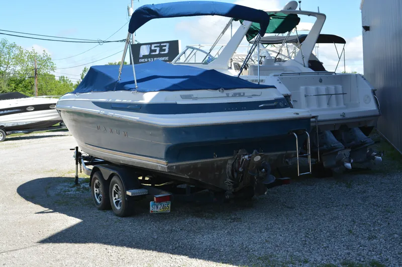 Slide: The Image of 1997 Maxum 2300 SR boat on trailer, covered and parked outdoors. - 2