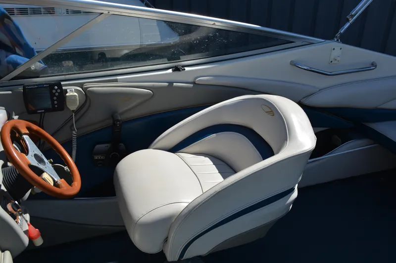 Slide: The Image of 1997 Maxum 2300 SR boat interior with white and blue seating, wooden steering wheel. - 8