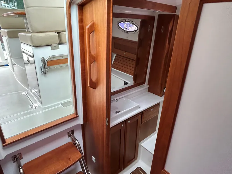 Slide: The Image of 2018 Back Cove 32 yacht interior with wooden cabinetry and compact bathroom. - 13