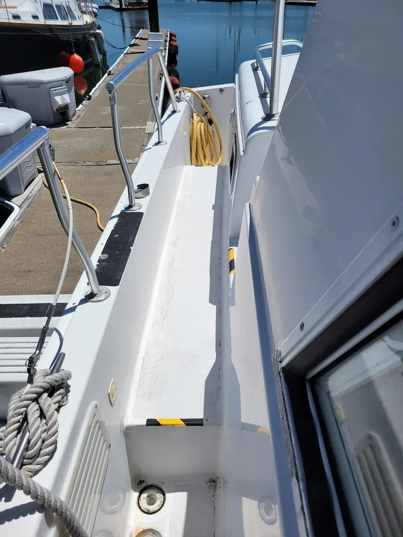 Slide: The Image of 1999 Mainship 430 Trawler deck view with dockside ropes and railing. - 10