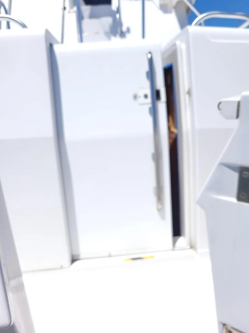 Slide: The Image of 1999 Mainship 430 Trawler, white exterior, open door, bright sunlight. - 15