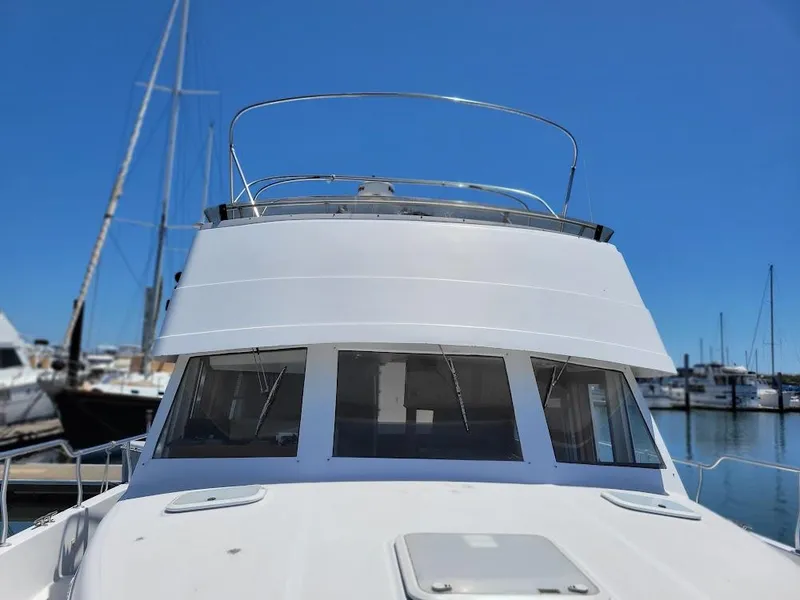 Slide: The Image of 1999 Mainship 430 Trawler docked at marina under clear blue sky. - 21