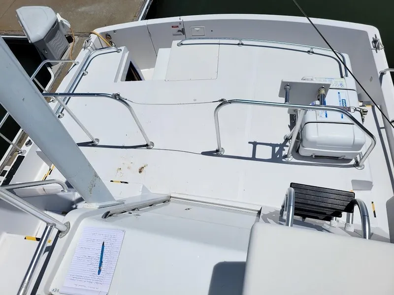 Slide: The Image of 1999 Mainship 430 Trawler deck view with seating and railing, docked at marina. - 22