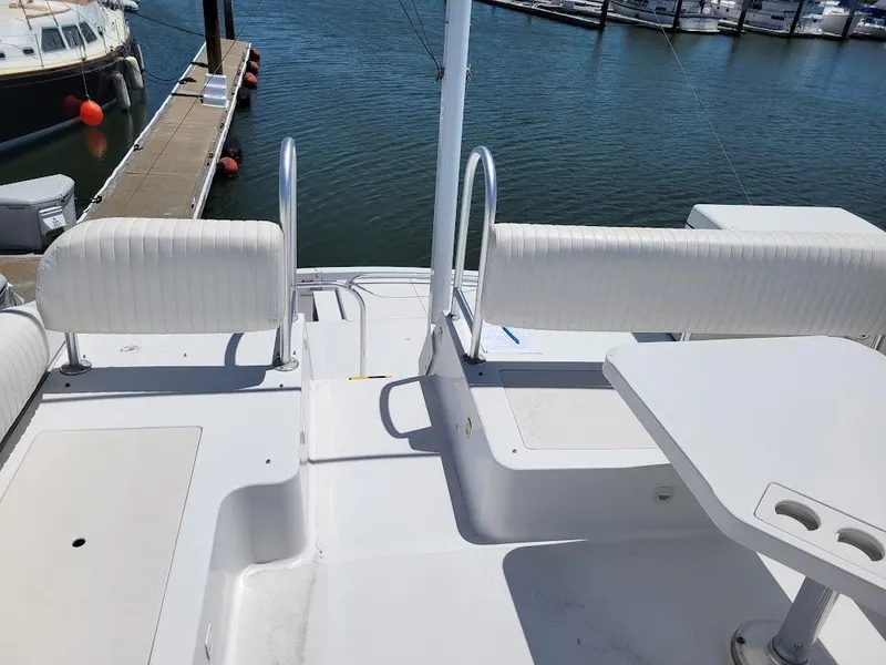 Slide: The Image of 1999 Mainship 430 Trawler deck with seating and table, docked at marina. - 23