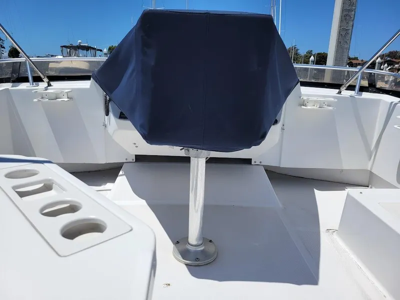 Slide: The Image of 1999 Mainship 430 Trawler helm with covered seat and cup holders on deck. - 25