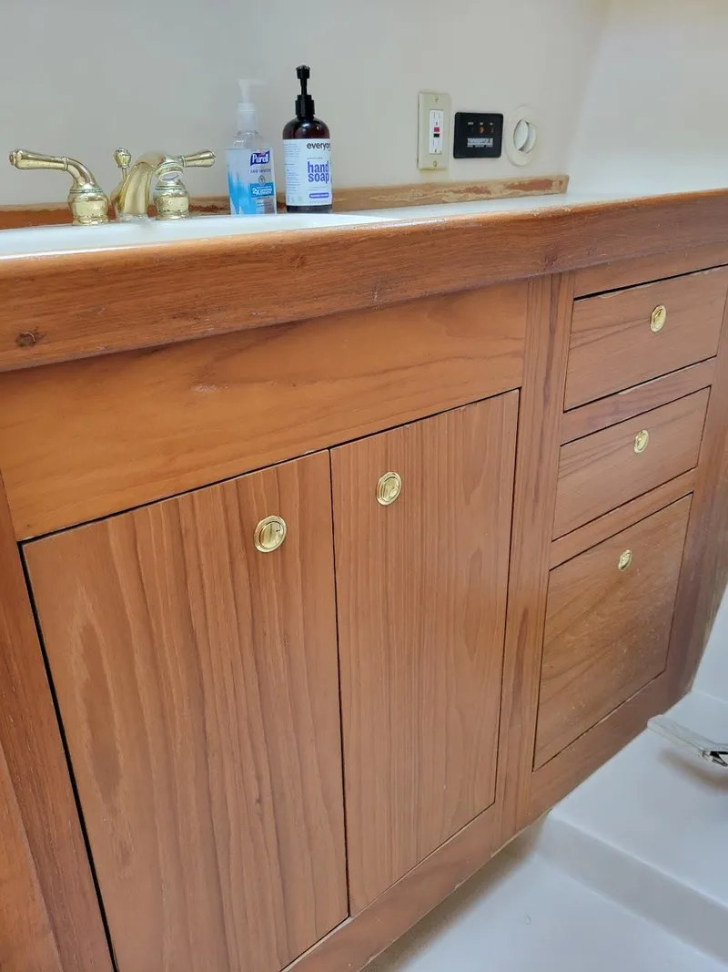 Slide: The Image of Wooden cabinetry with brass handles in a 1999 Mainship 430 Trawler bathroom. - 43