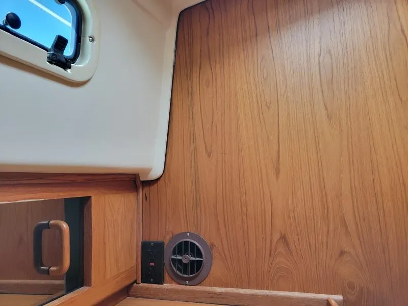 Slide: The Image of Interior of 1999 Mainship 430 Trawler with wood paneling and small window. - 49