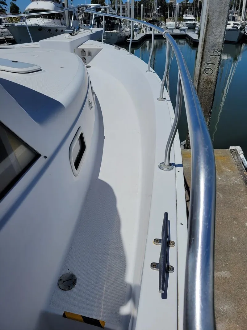 Slide: The Image of 1999 Mainship 430 Trawler deck with railing, docked at marina. - 8