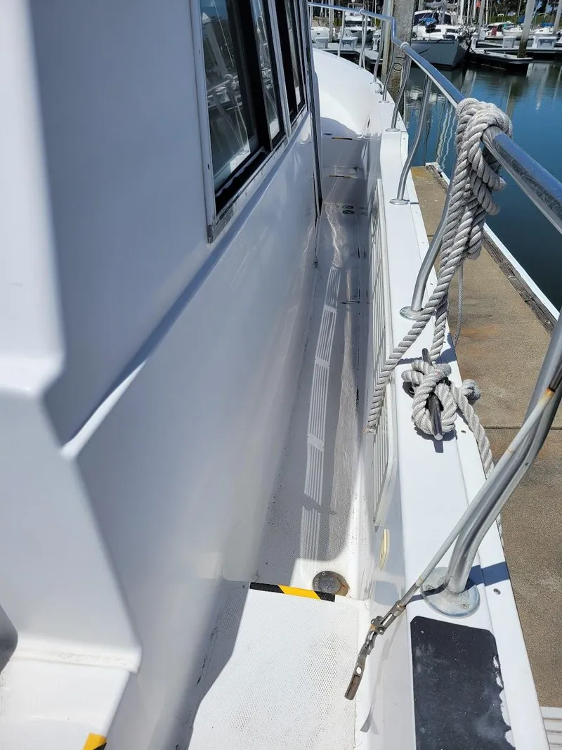 Slide: The Image of 1999 Mainship 430 Trawler deck with railing and rope, docked at marina. - 9