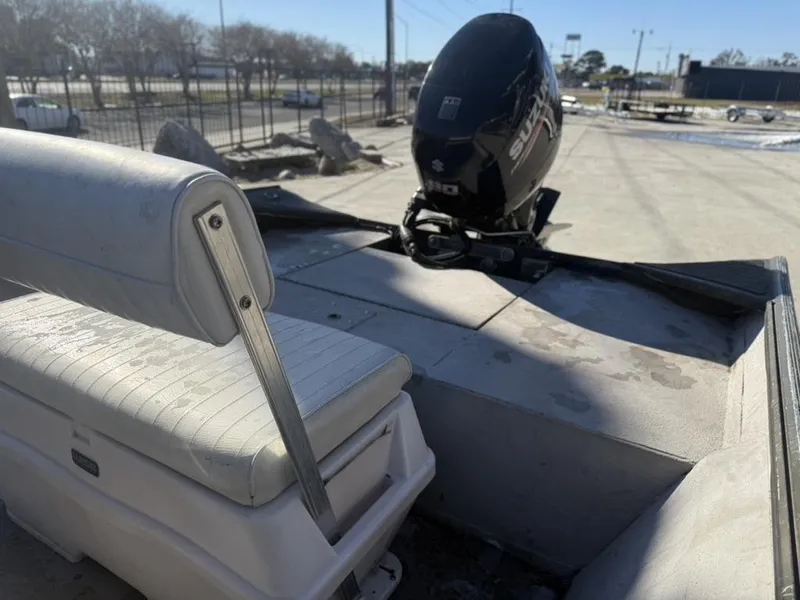 Slide: The Image of War Eagle 18 boat with Suzuki outboard motor and white seating, parked outdoors. - 10