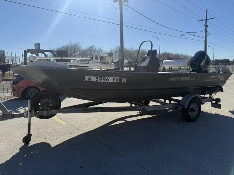 Slide: The Image of 2000 War Eagle 18 boat on trailer, parked outdoors under clear sky. - 4
