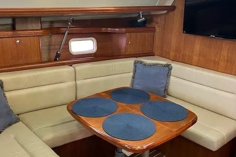 Slide: The Image of Interior of 2006 Hunter 44 Deck Salon with beige seating and wooden table. - 23