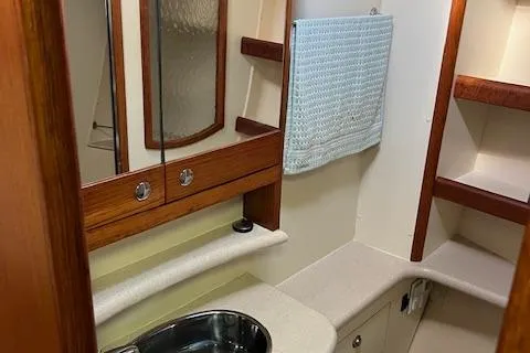 Slide: The Image of Interior of 2006 Hunter 44 Deck Salon bathroom with sink and wooden cabinetry. - 34