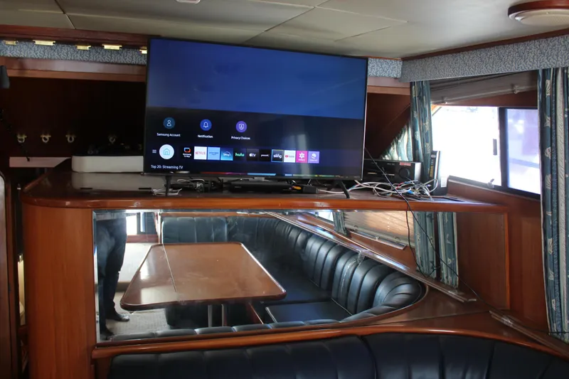 Slide: The Image of Interior of a 1994 Mikelson 64 yacht with a TV and dining area. - 13