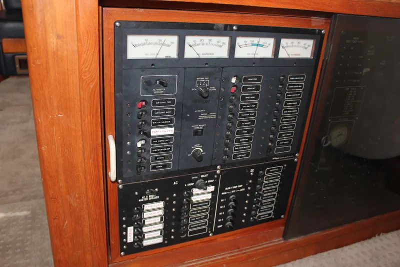 Slide: The Image of Electrical control panel on a 1994 Mikelson 64 yacht, featuring gauges and switches. - 19