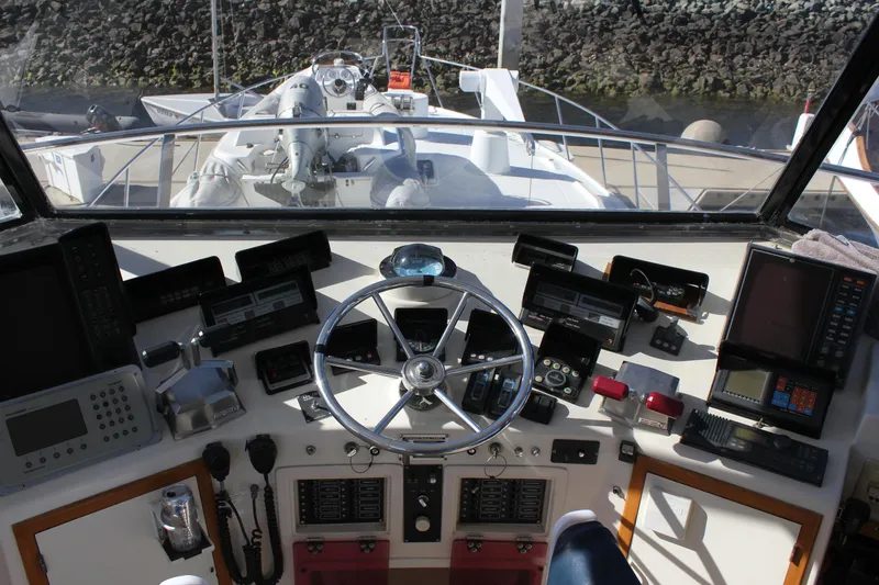 Slide: The Image of Cockpit view of a 1994 Mikelson 64 yacht with navigational instruments and steering wheel. - 22