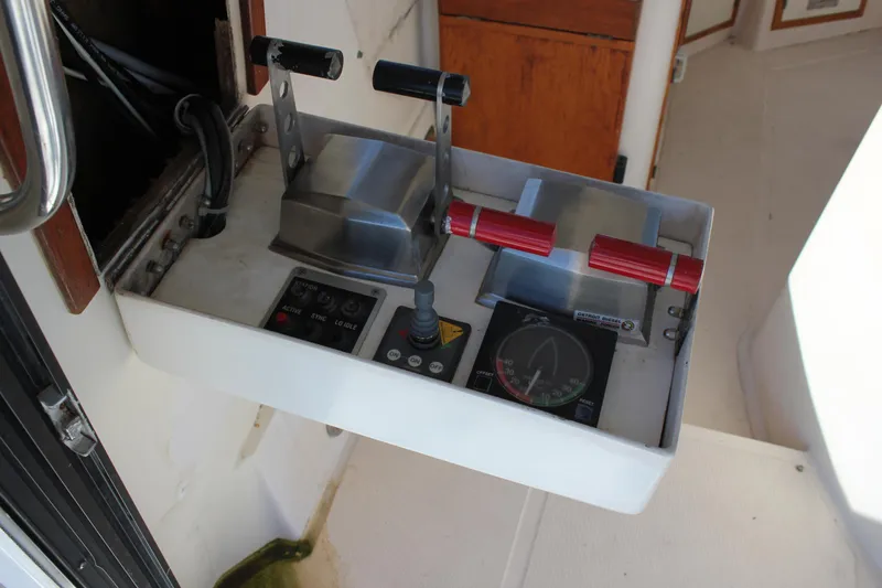 Slide: The Image of Control panel of a 1994 Mikelson 64 yacht with throttle levers and navigation instruments. - 24