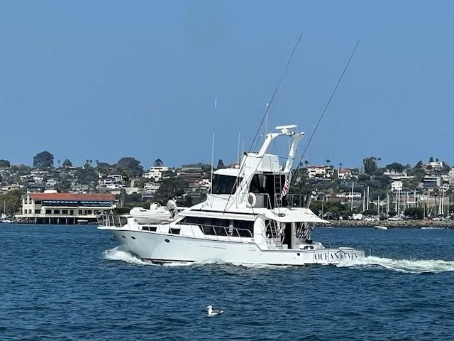 Slide: The Image of 1994 Mikelson 64 yacht cruising on a sunny day near coastal town. - 3