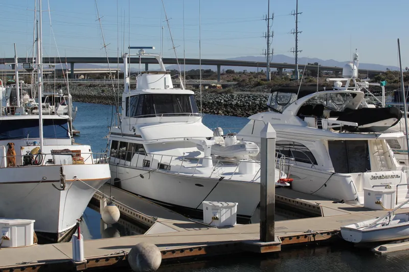 Slide: The Image of Docked 1994 Mikelson 64 yacht in marina, surrounded by other boats, clear sky background. - 30