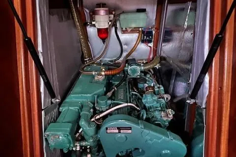 Slide: The Image of Engine compartment of a 2000 Bavaria 42 Cruiser sailboat, showcasing mechanical components. - 17