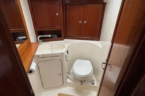 Slide: The Image of Bathroom interior of a 2000 Bavaria 42 Cruiser yacht, featuring wooden cabinets and compact design. - 34