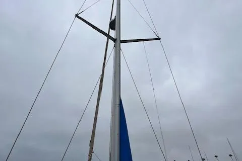 Slide: The Image of Mast of a 2000 Bavaria 42 Cruiser sailboat against a cloudy sky. - 46