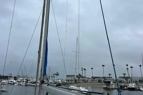 Slide: The Image of Sailboats docked in a marina under cloudy skies, featuring a Bavaria 42 Cruiser, 2000 model. - 47