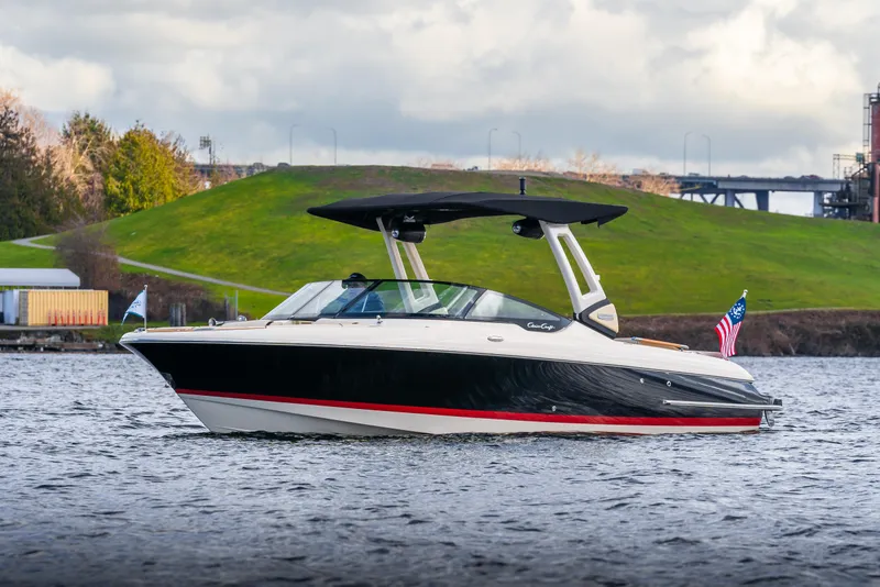 Slide: The Image of 2025 Chris-Craft Sportster 25 boat on water, sleek design, American flag, scenic background. - 1