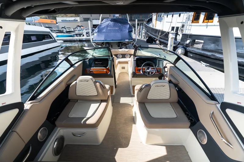 Slide: The Image of 2025 Chris-Craft Sportster 25 interior with luxurious seating and modern dashboard at a marina. - 4