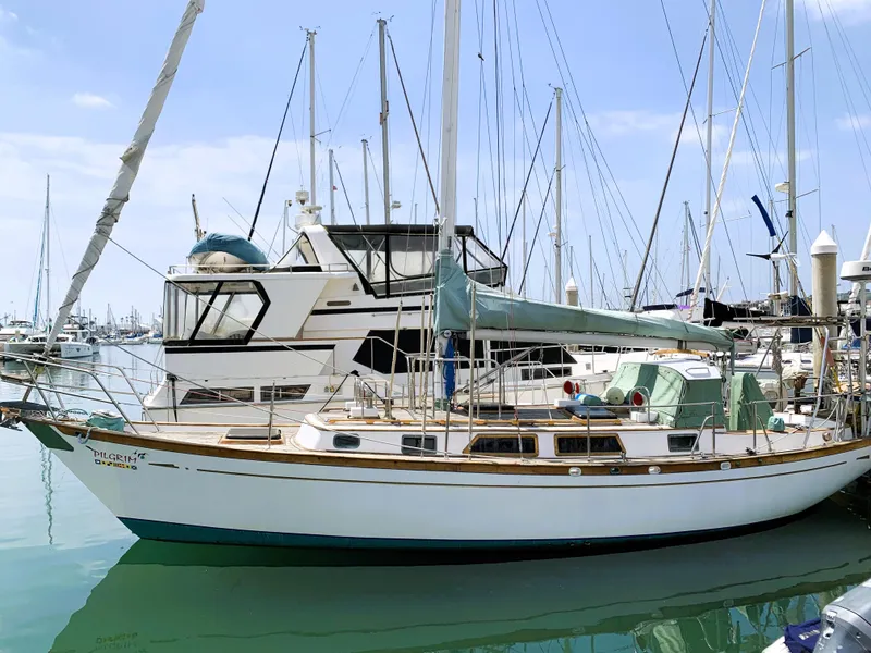 The Image of 1979 Robert Perry 41 Sloop docked in a marina, surrounded by other boats. - 1