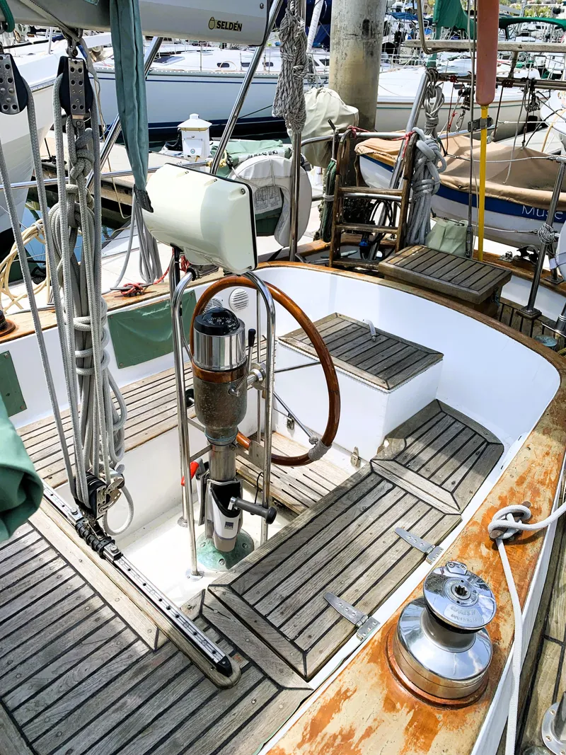 Slide: The Image of 1979 Robert Perry 41 Sloop sailboat cockpit with wooden deck and steering wheel. - 16