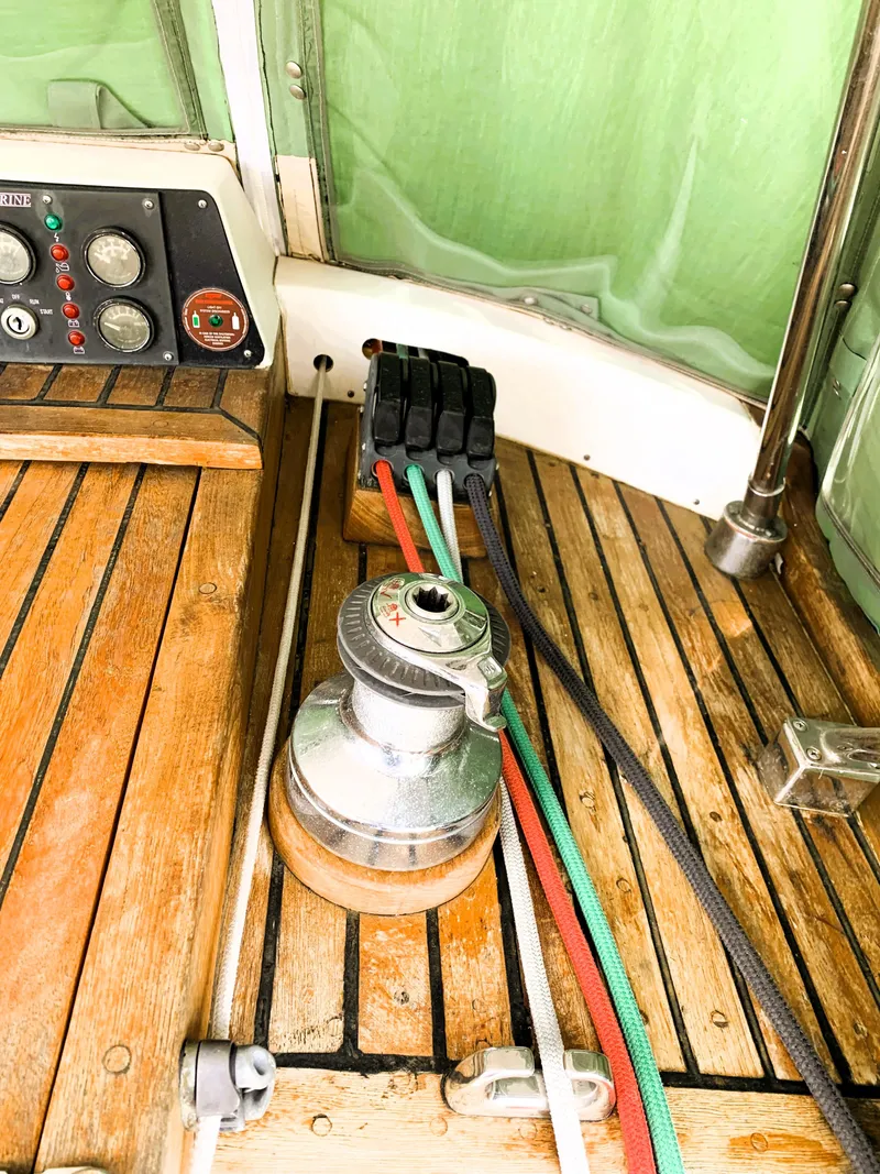 Slide: The Image of 1979 Robert Perry 41 Sloop cockpit with winch, control panel, and colorful ropes. - 22