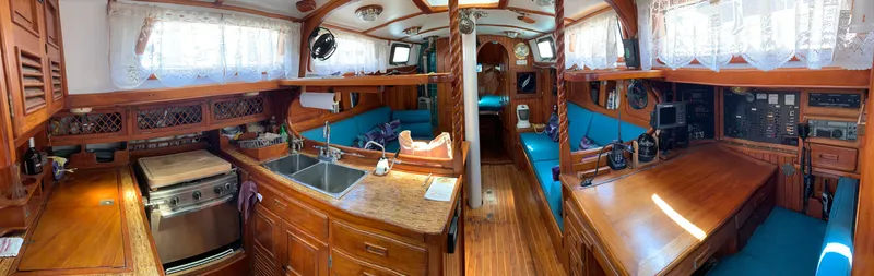 Slide: The Image of Interior of 1979 Robert Perry 41 Sloop, featuring wooden cabinetry and blue seating. - 29