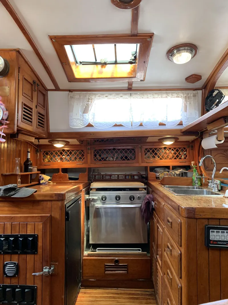 Slide: The Image of 1979 Robert Perry 41 Sloop kitchen with wooden cabinetry and stainless steel appliances. - 32