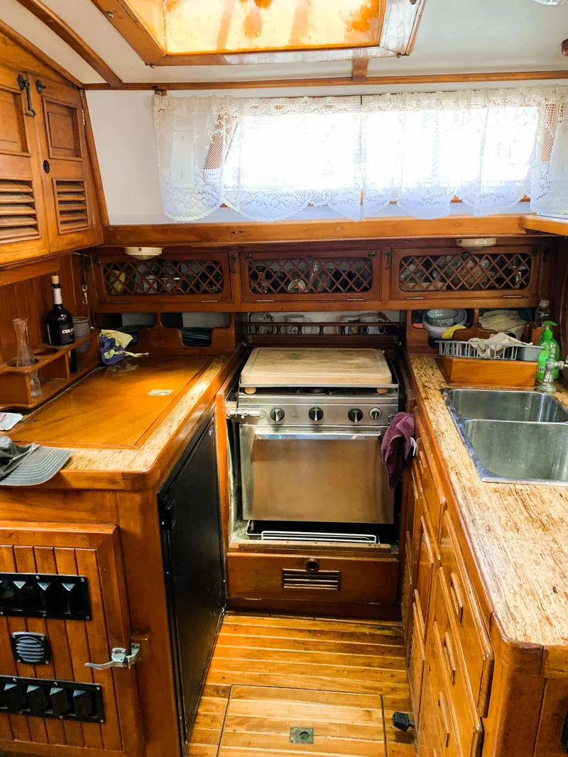 Slide: The Image of 1979 Robert Perry 41 Sloop interior kitchen with wooden cabinetry and stainless steel appliances. - 36