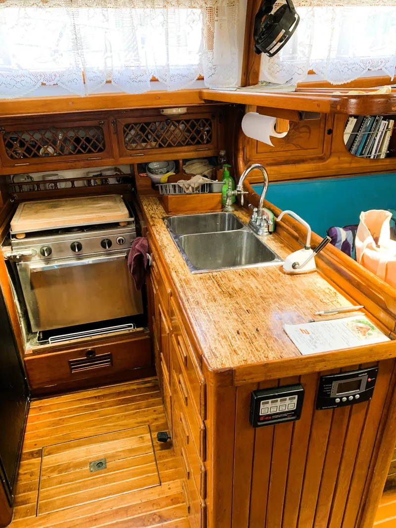Slide: The Image of 1979 Robert Perry 41 Sloop kitchen with wooden cabinetry, sink, and stove. - 37