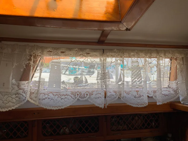 Slide: The Image of Interior of 1979 Robert Perry 41 Sloop with lace curtains and wooden trim. - 40