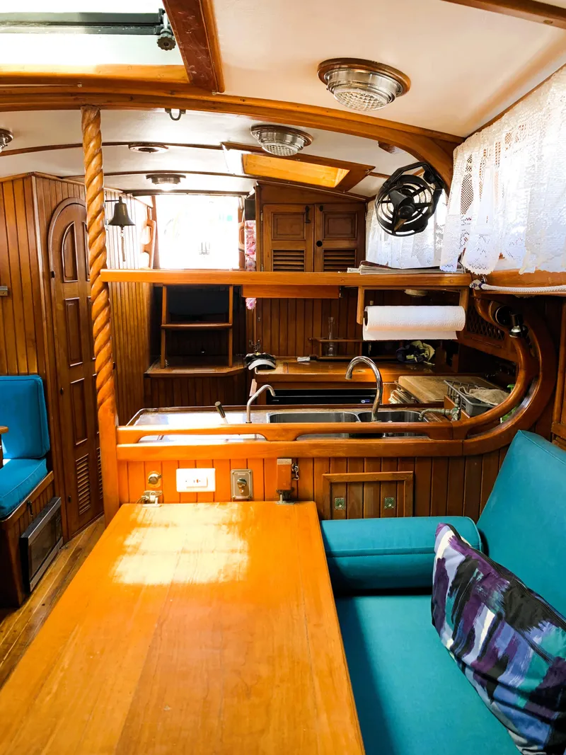 Slide: The Image of 1979 Robert Perry 41 Sloop interior with wooden finishes and blue seating. - 48