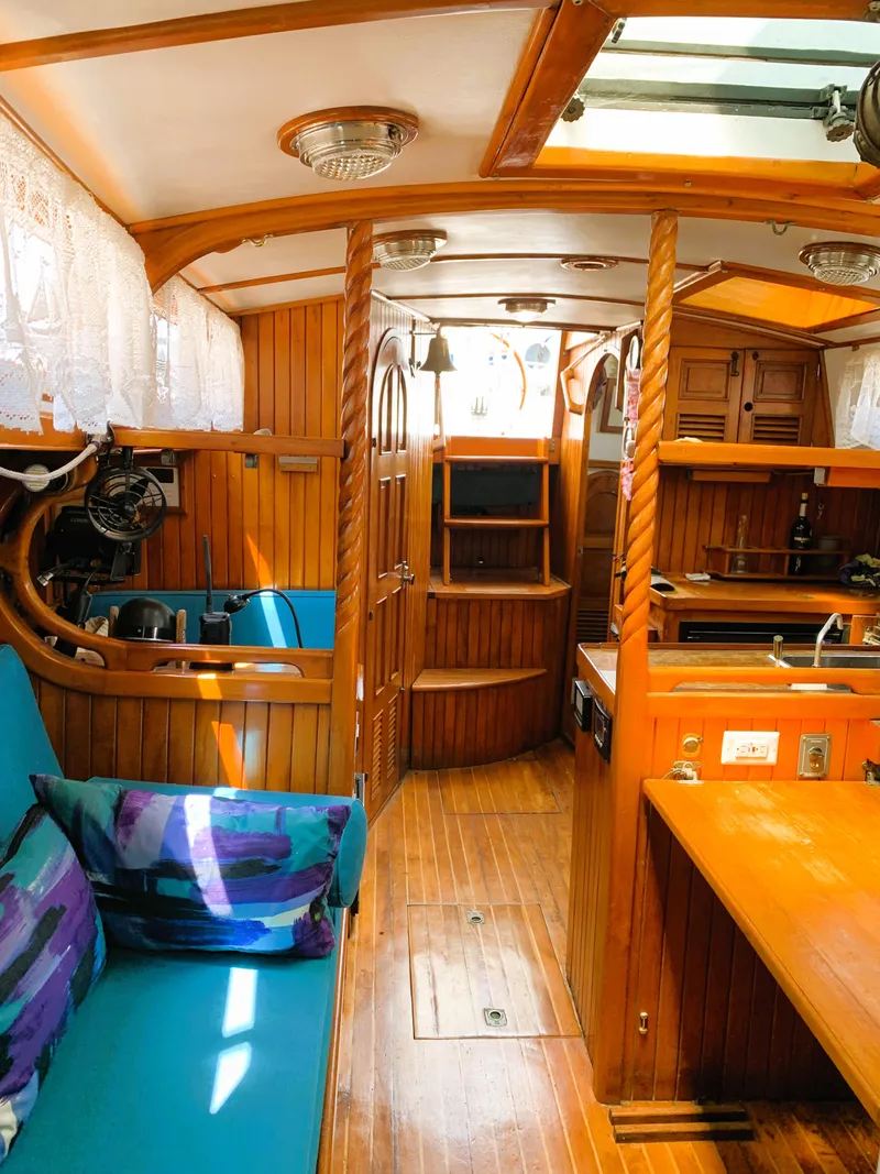 Slide: The Image of Interior of a 1979 Robert Perry 41 Sloop, featuring wooden finishes and cozy seating. - 49