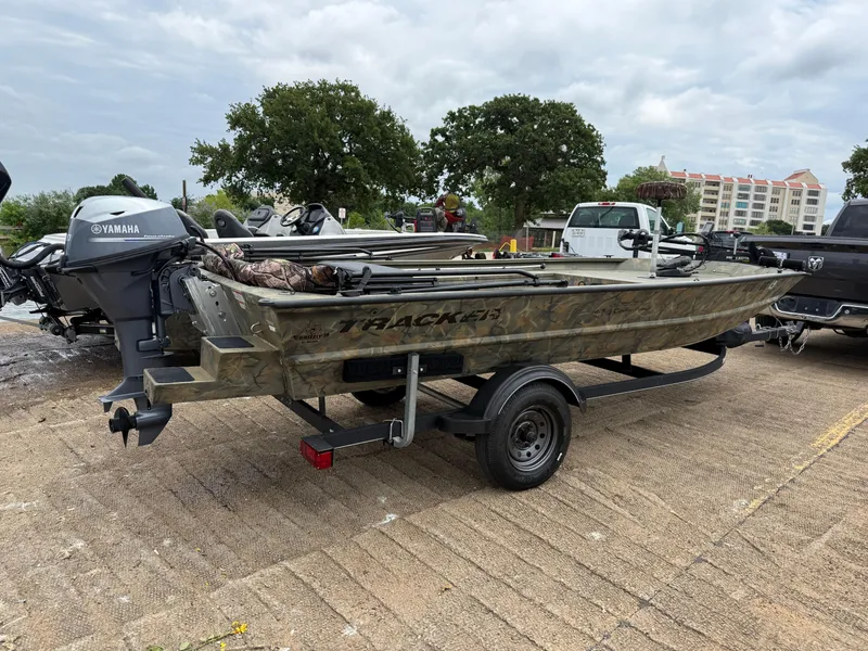 Slide: The Image of 2017 Tracker Grizzly 1654 MVX Sportsman boat on trailer, parked outdoors. - 11