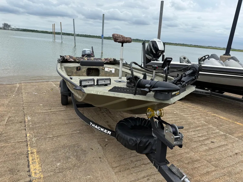 Slide: The Image of 2017 Tracker Grizzly 1654 MVX Sportsman boat on trailer by the water. - 15