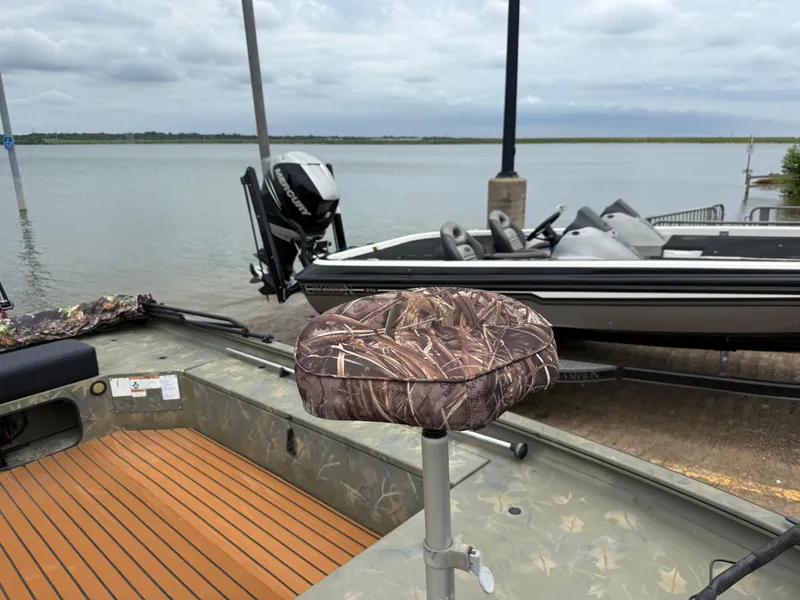 Slide: The Image of 2017 Tracker Grizzly 1654 MVX Sportsman boat with camo seat by the water. - 18