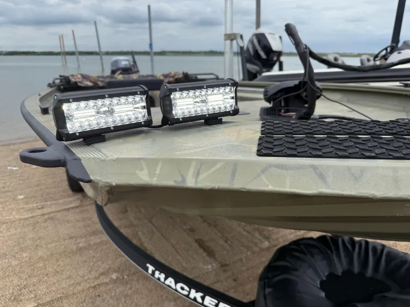 Slide: The Image of 2017 Tracker Grizzly 1654 MVX Sportsman boat with LED lights on a sandy shore. - 22