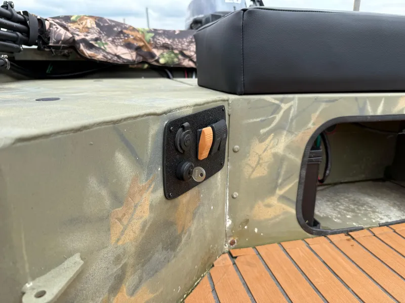 Slide: The Image of 2017 Tracker Grizzly 1654 MVX Sportsman boat interior with camo design and control panel. - 24