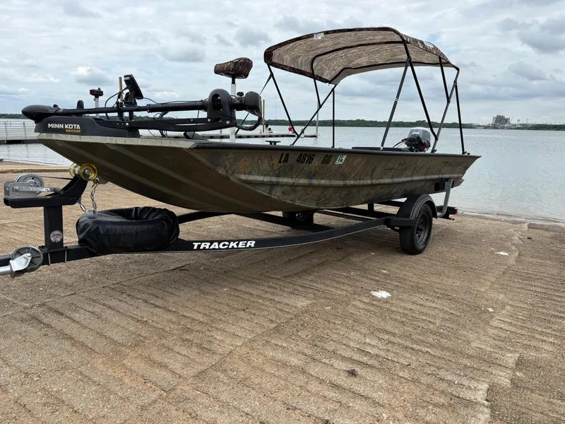 Slide: The Image of 2017 Tracker Grizzly 1654 MVX Sportsman boat on trailer by lake. - 34