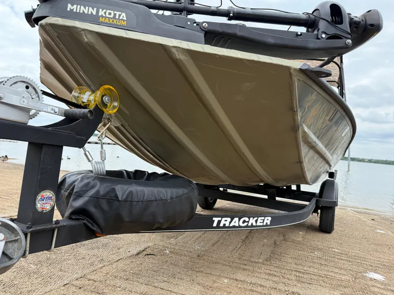 Slide: The Image of 2017 Tracker Grizzly 1654 MVX Sportsman boat on trailer by lake. - 35