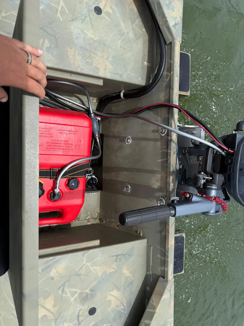 Slide: The Image of 2017 Tracker Grizzly 1654 MVX Sportsman boat with red fuel tank and motor on water. - 38