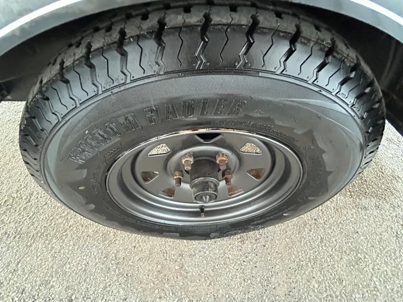 Slide: The Image of 2017 Tracker Grizzly 1654 MVX Sportsman tire on asphalt surface. - 46