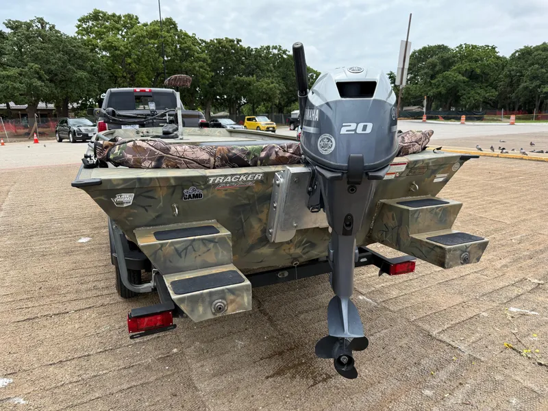 Slide: The Image of 2017 Tracker Grizzly 1654 MVX Sportsman boat with Yamaha 20 motor, parked outdoors. - 5